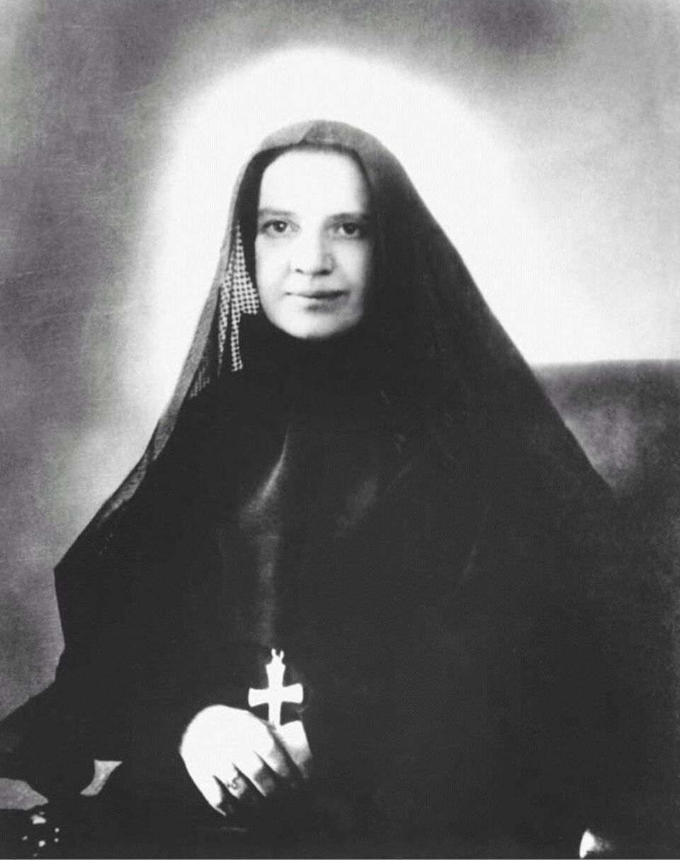 Photograph of St. Frances Xavier Cabrini in a dark religious habit with a white collar, seated and looking toward the viewer.