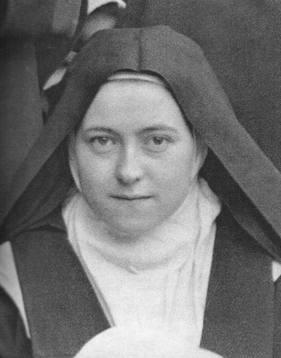 Photograph of St. Thérèse of Lisieux as a young Carmelite nun in habit and veil, looking directly at the camera.